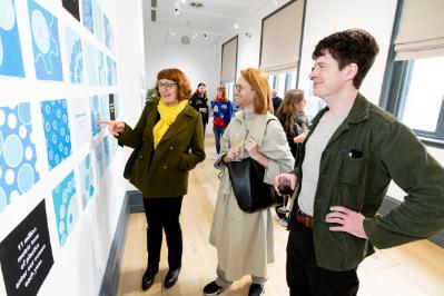 Attendees enjoying Prof. Ingrid Hess' art exhibition 'Full of Wonder or Full of Plastic? You Decide' in the Naughton Gallery.